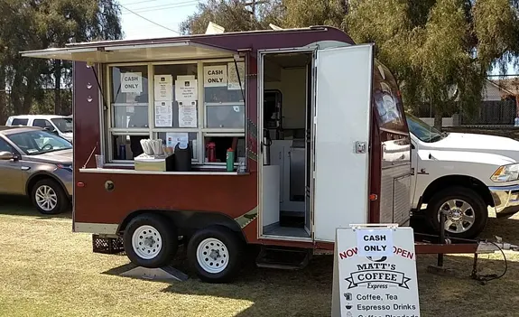 Mobile coffee truck with open service window and menu signage.