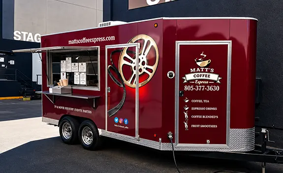 Red mobile coffee truck parked on street with service window open.